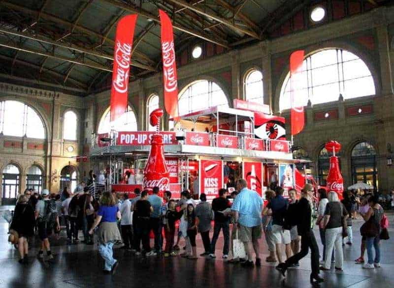 oryg_064490685_1129949550544944_1465385417682452480_o Tłum ludzi przed sklepem tymczasowym Coca-Coli w hali dworcowej.