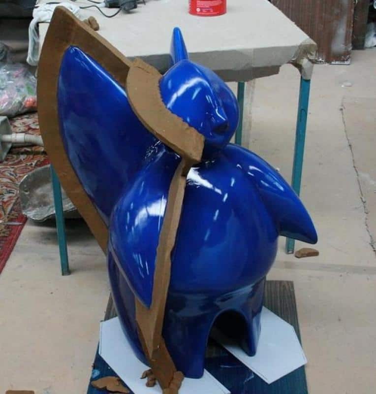 Futurystyczny anioł na stoisko targowe 4 Niebieska figurka w foremce z brązowego kartonu, umieszczona na stole roboczym.