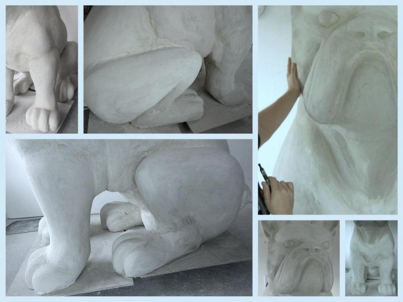 Rzeźba psa w trakcie tworzenia, przedstawiająca szczegóły nóg, łap i pyska.