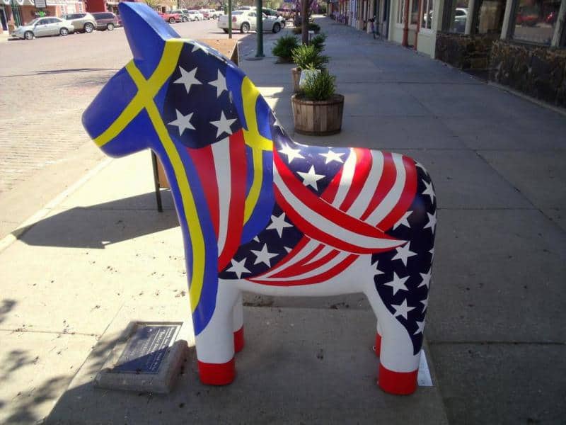 oryg_064490685_1129949550544944_1465385417682452480_o Kolorowy posąg konia z motywem flagi Stanów Zjednoczonych na ulicy.
