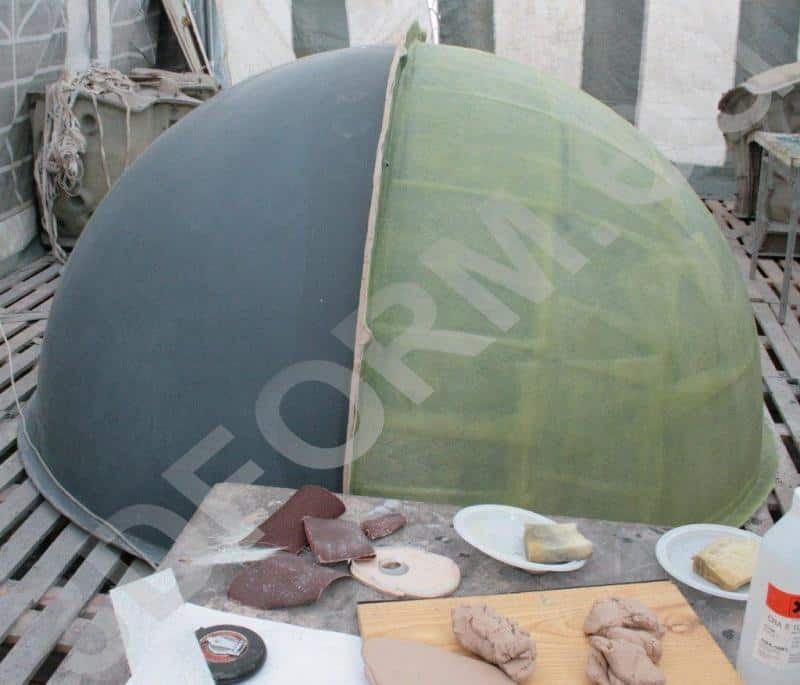 Wielka kula w przestrzeni miejskiej 3 Półokrągła konstrukcja w dwóch kolorach, otoczona narzędziami rzemieślniczymi na drewnianej podłodze.