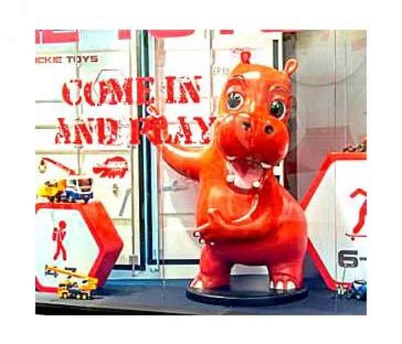 Czerwona figurka hipopotama w witrynie sklepowej z napisem 