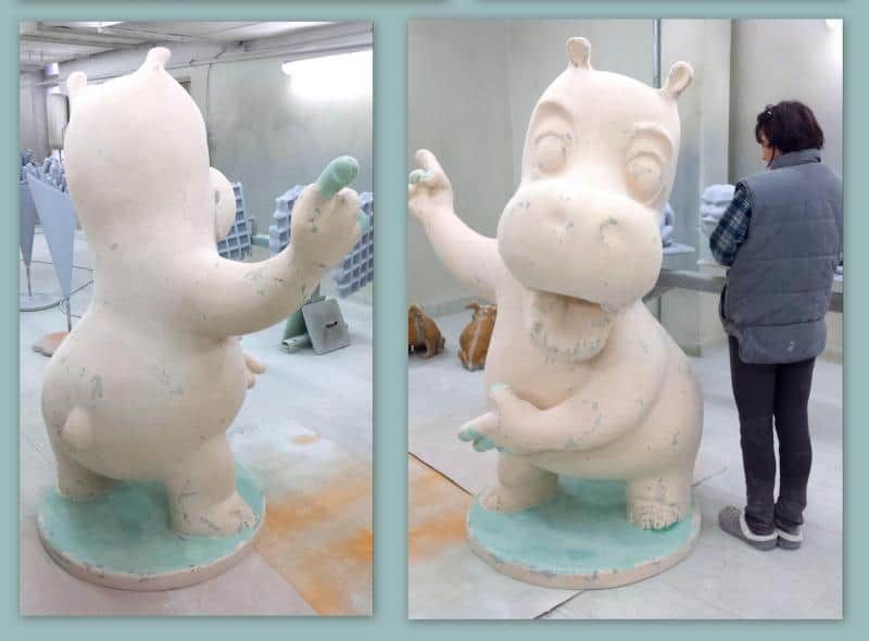 Rzeźba hipopotama w pracowni, obok stoi osoba.
