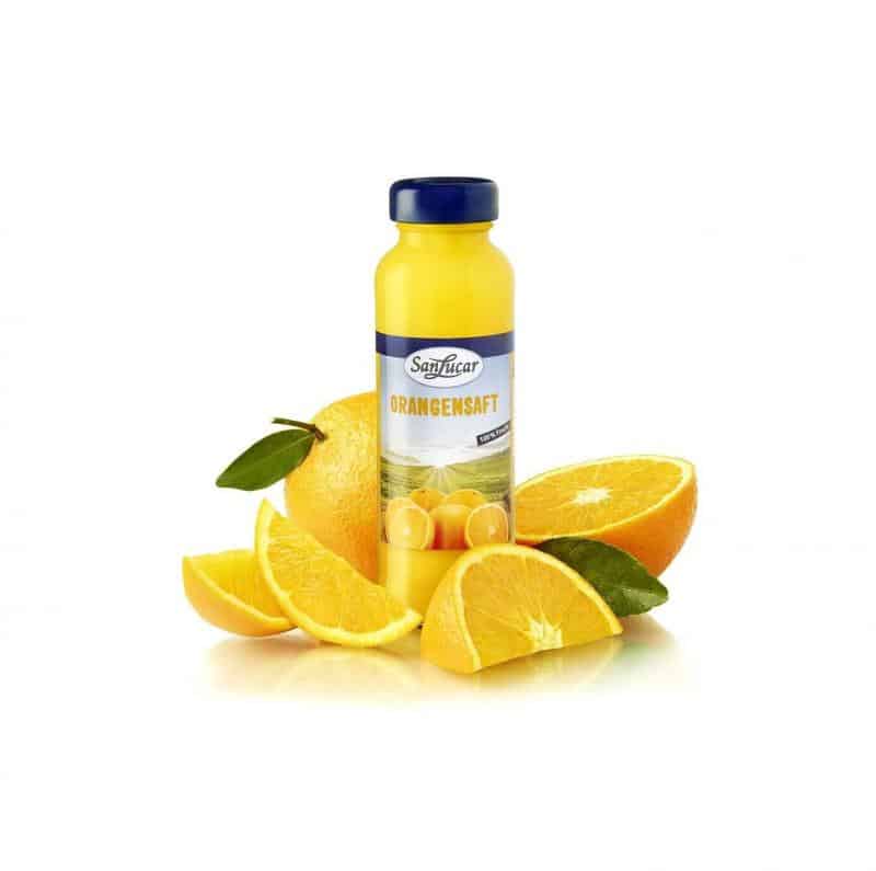 Butelka soku 2 Butelka soku pomarańczowego SanLucar otoczona kawałkami pomarańczy.