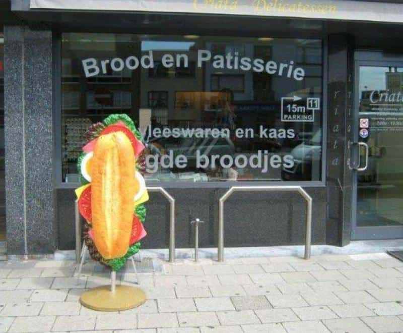 oryg_064490685_1129949550544944_1465385417682452480_o Wejście do piekarni z reklamą kanapki.