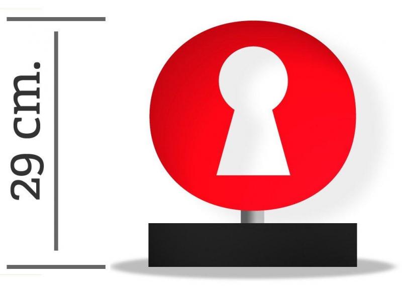 Czerwona okrągła tablica z białą dziurką od klucza na czarnej podstawie; wysokość 29 cm.