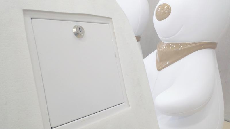 Królik skarbonka 2 biała skrzynka zamykana na klucz na tle dużych, białych figur przypominających misie