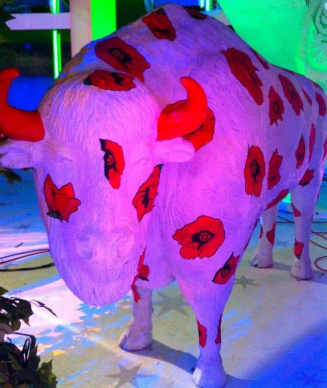 Żubry w „Kocham Cię Polsko” 4 Rzeźba byka pomalowana na biało, z czerwonymi makami i czerwonymi rogami.