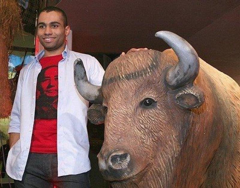 Żubry w „Kocham Cię Polsko” 1 Mężczyzna stojący obok rzeźby żubra, trzymający rękę na jego grzbiecie.