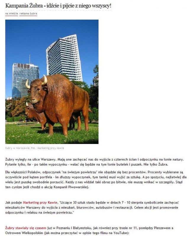 Figury reklamowe piwa ŻUBR 4 Żubr, figurka żubra na tle wieżowców w Warszawie.