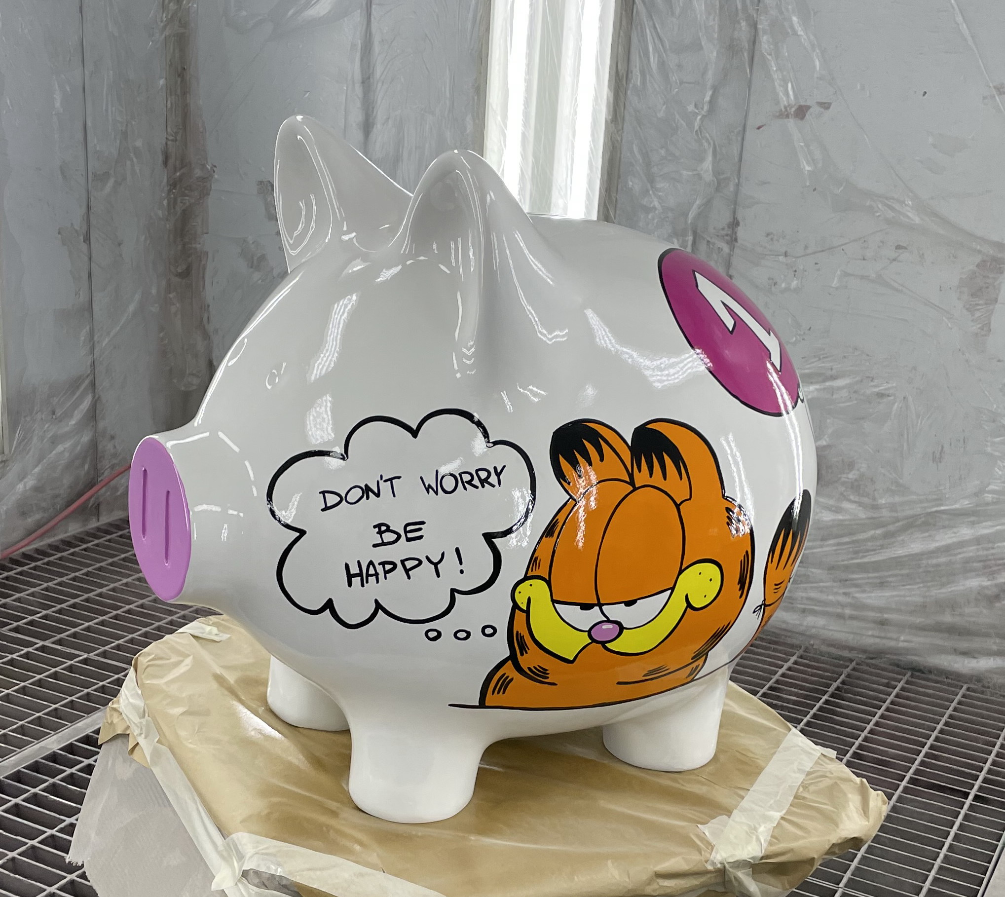 Duża Świnka skarbonka, wersja pop art 2 Biała skarbonka w kształcie świni z namalowanym rysunkiem Garfielda i napisem