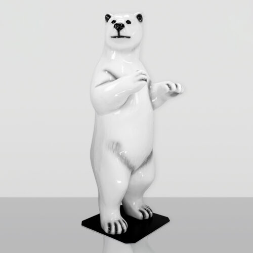Biała ceramiczna figurka niedźwiedzia polarnego stojącego na tylnych łapach na czarnej podstawie, na jasnym tle.