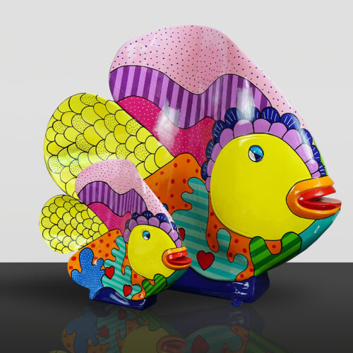 Kolorowe, abstrakcyjne rzeźby dwóch ryb, jedna większa, druga mniejsza, z wzorami w kropki, paski i serduszka.