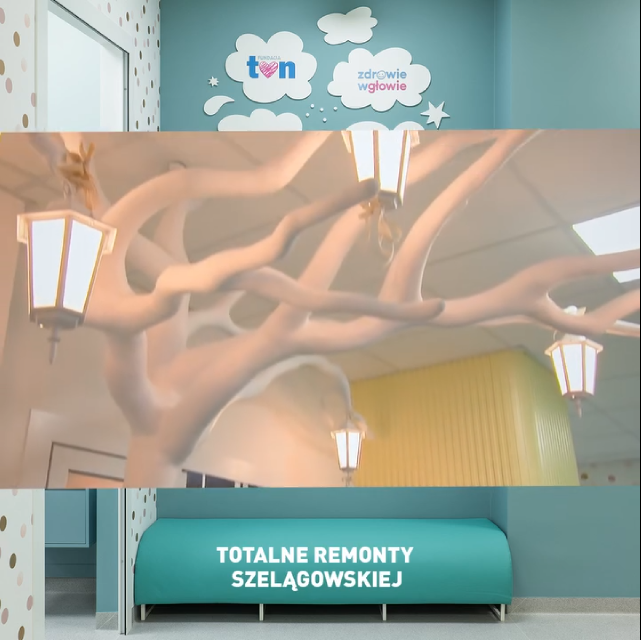 Korytarz szpitalny z dekoracjami przypominającymi gałęzie drzew z lampionami, logo 