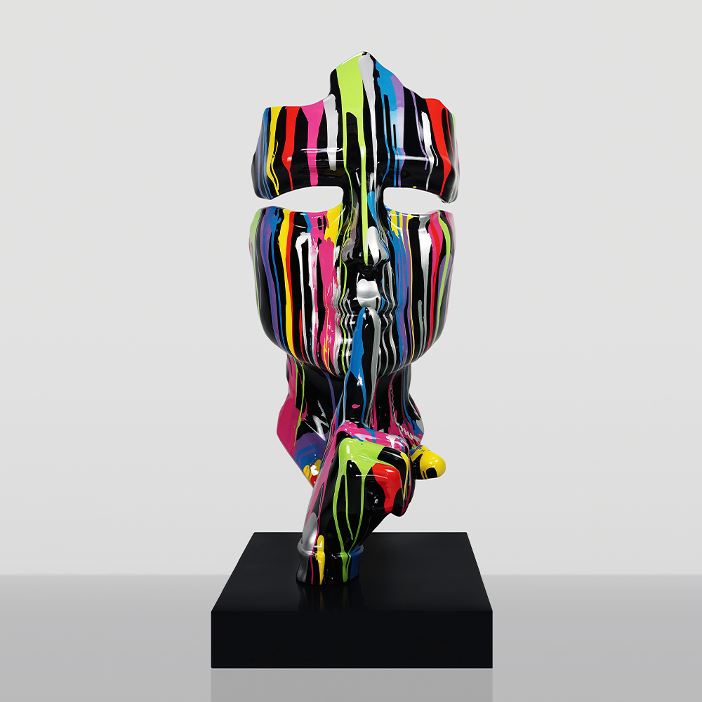 Średniej Wielkości 120CM Maska Na Podstawie - Czarny Trash 1 Nowoczesna rzeźba głowy z palcem na ustach w geście ciszy, pokryta kolorowymi, pionowymi smugami farby, stojąca na czarnym postumencie na szarym tle