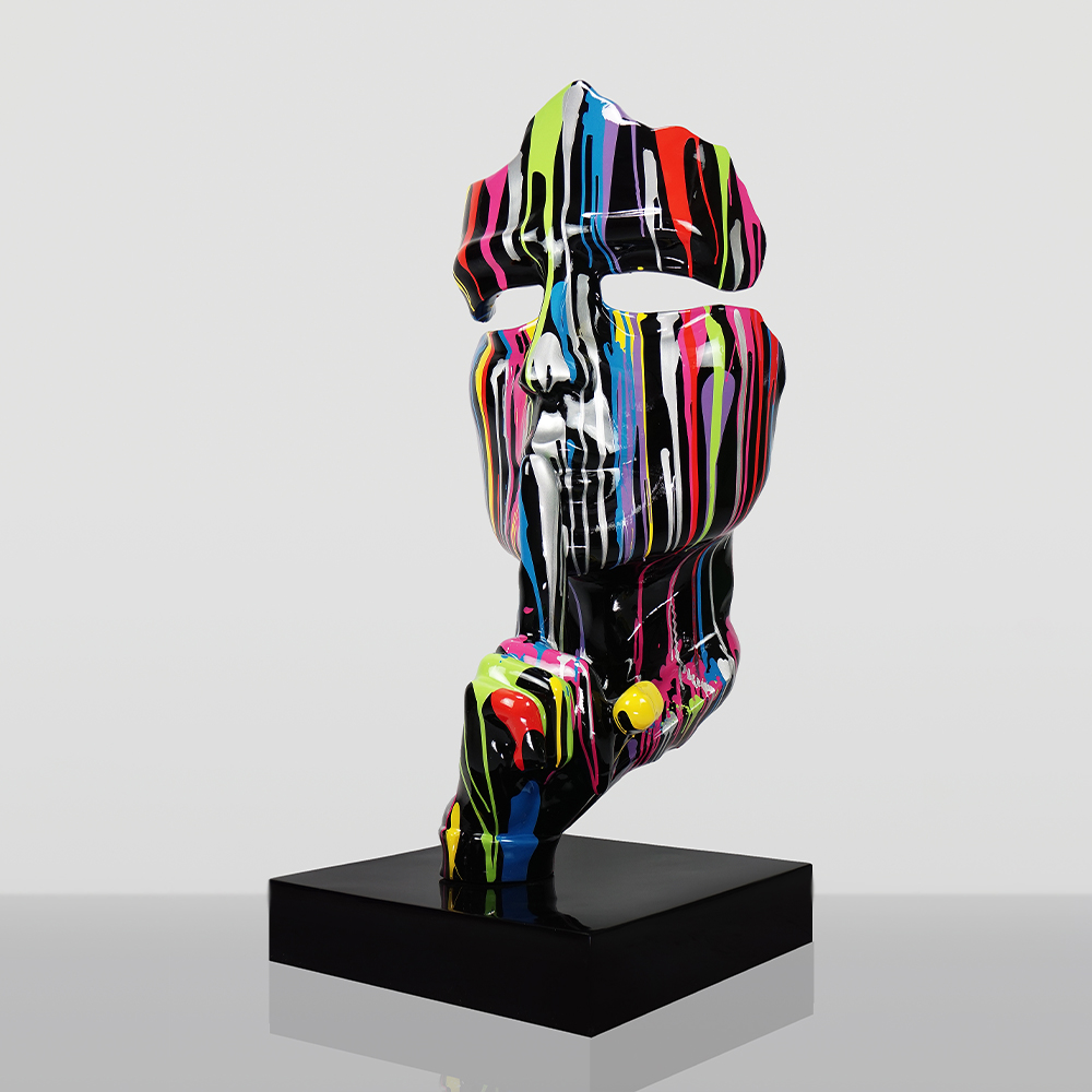 Średniej Wielkości 120CM Maska Na Podstawie - Czarny Trash 2 Rzeźba abstrakcyjnej twarzy z wyciętymi oczami, pomalowana czarną farbą z pionowymi kolorowymi smugami na biały, szarym tle, umieszczona na czarnej podstawce.