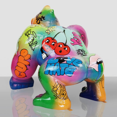Kolorowa figura goryla w pozycji czworonożnej pokryta graffiti, w tym czerwonymi wisienkami z twarzami, napisem