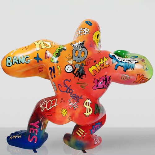 Kolorowa abstrakcyjna rzeźba w kształcie postaci z dużymi kończynami, pokryta graffiti z napisami i symbolami takimi jak 