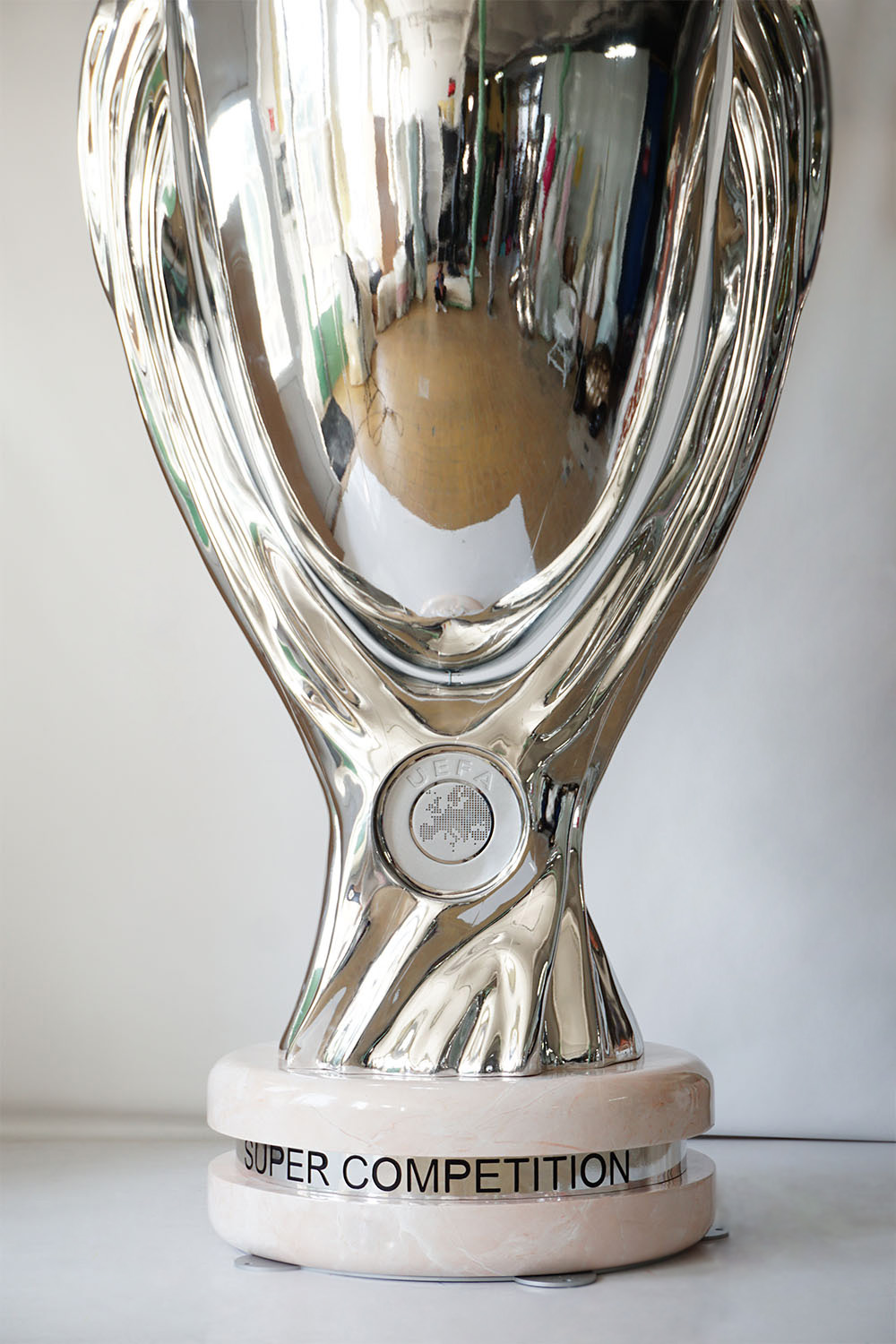 srebrny puchar UEFA Super Competition na marmurowej podstawie z czarnym napisem SUPER COMPETITION na białym tle