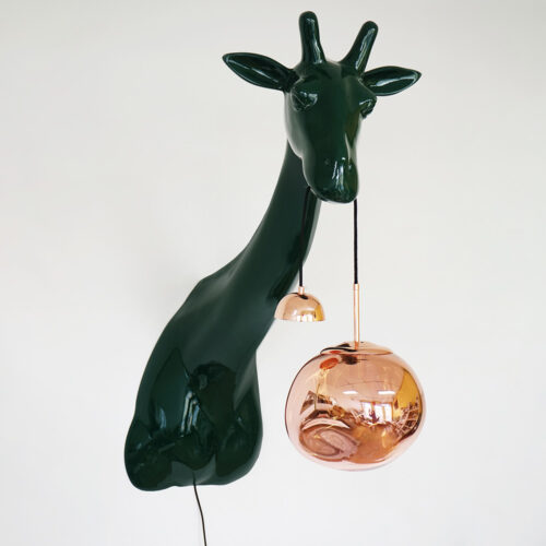 Nowoczesna lampa ścienna w kształcie głowy żyrafy w ciemnozielonym kolorze, z wiszącym szklanym kloszem w kolorze miedzi, na białym tle.